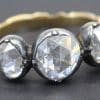 Diamond ring with three large, clear gemstones and a gold band.