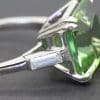 Elegant green gemstone engagement ring with silver band.