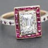 Elegant diamond ring featuring an emerald-cut center stone surrounded by pink gemstones and a diamon.