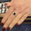 Elegant sapphire and diamond ring on a woman's finger, showcasing fine jewelry craftsmanship.