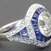 Elegant diamond and sapphire ring with intricate design and sparkling gemstones.
