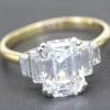 Elegant emerald cut diamond engagement ring with gold band.