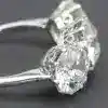 Engagement ring featuring a large central diamond surrounded by smaller stones, crafted in silver, f.