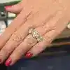 Diamond ring with three sparkling stones on a woman's finger.
