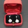 Diamond earrings in a vintage red jewelry box, perfect for special occasions or gifts.