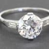 Diamond engagement ring with a large central stone and side baguette accents.