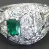 Elegant diamond and emerald ring with intricate design.