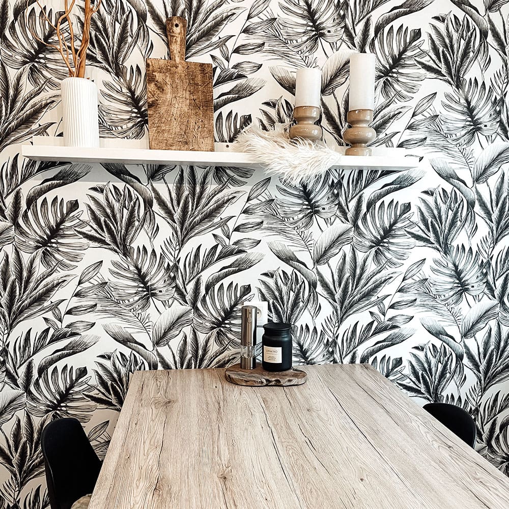 Espace repas avec table en bois et papier peint végétal tendance