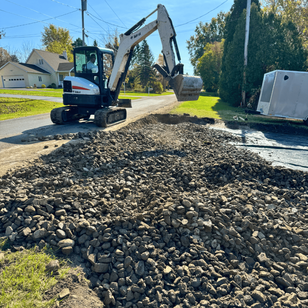 RCS excavator spreading stone on a driveway