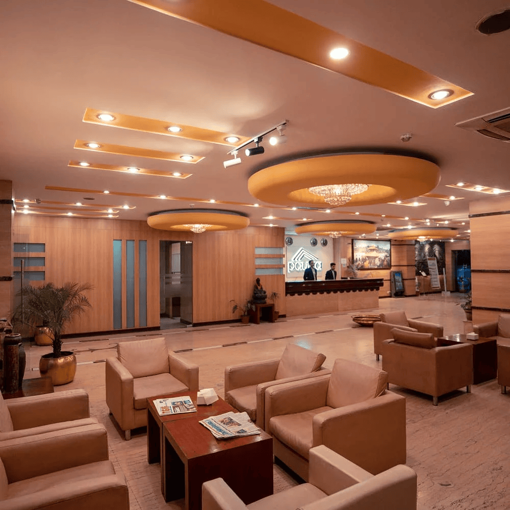 An interior view of a sophisticated and modern hotel lobby and reception area that is conspicuously empty, showing a lack of guests.