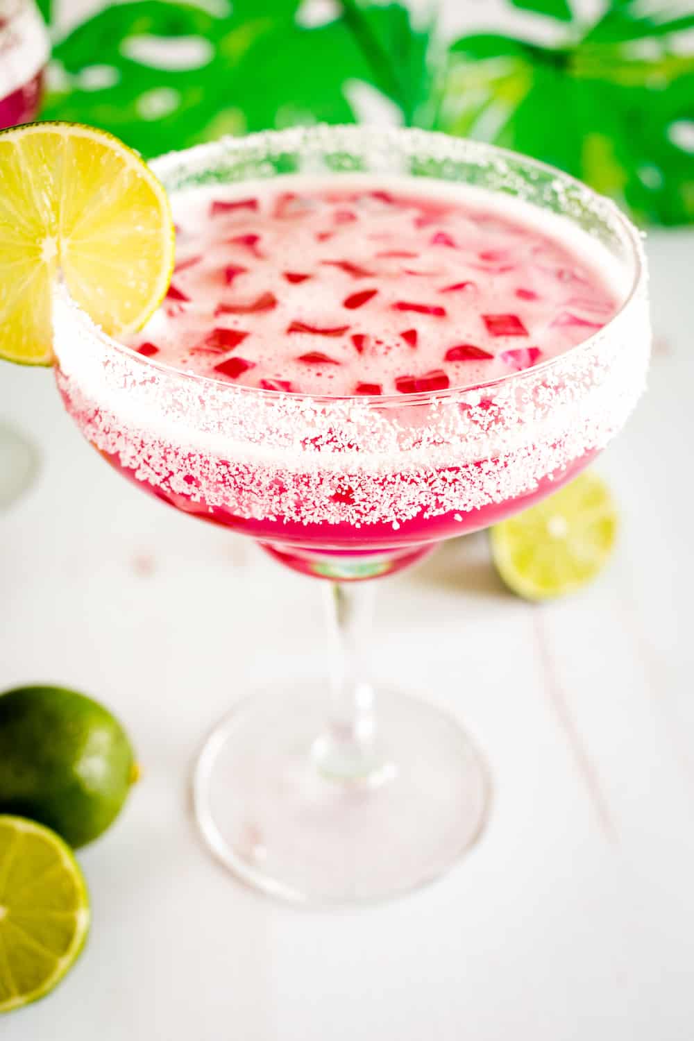 pink prickly pear margaritas surrounded by limes