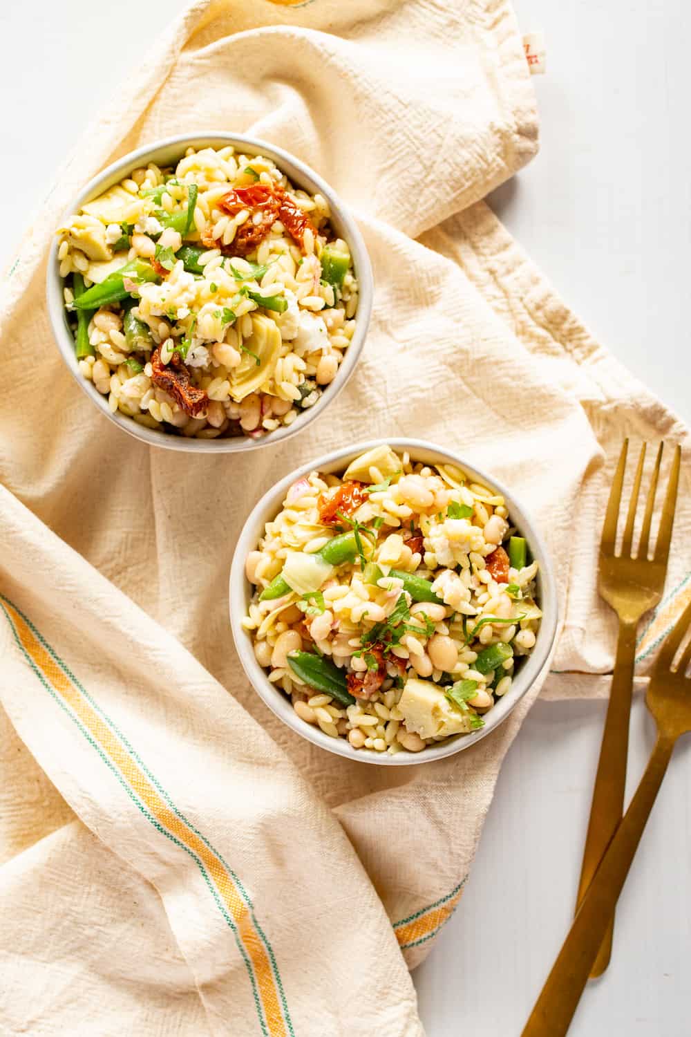 bowls of mediterranean orzo salad with green beans and sun-dried tomatoes