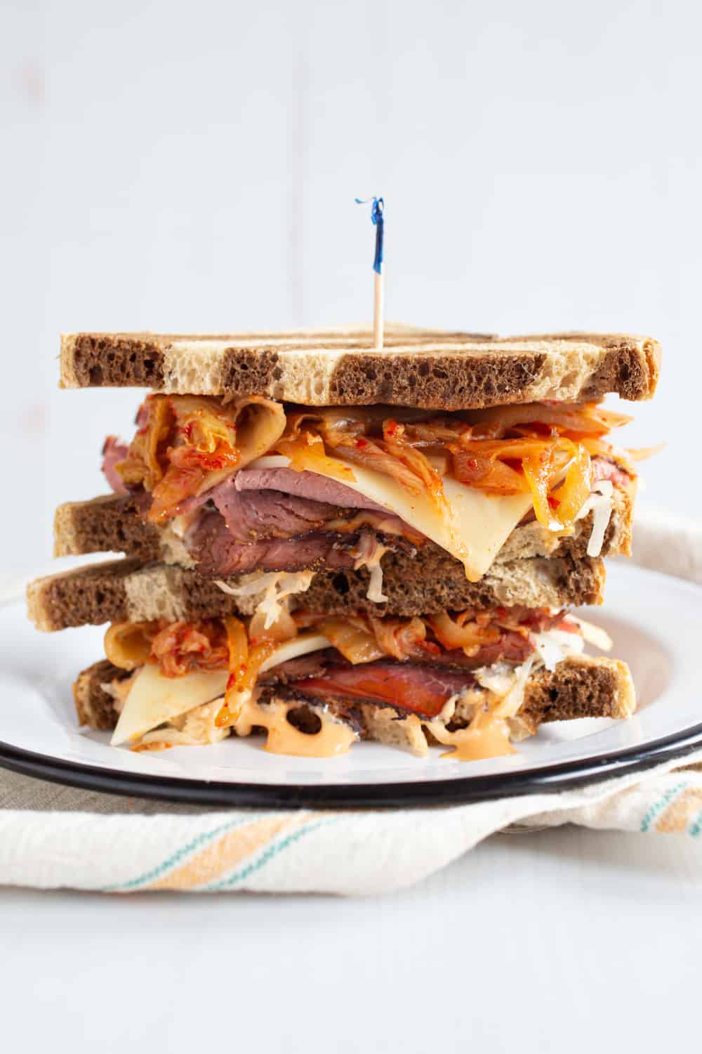 kimchi reuben sandwich stacked on a plate