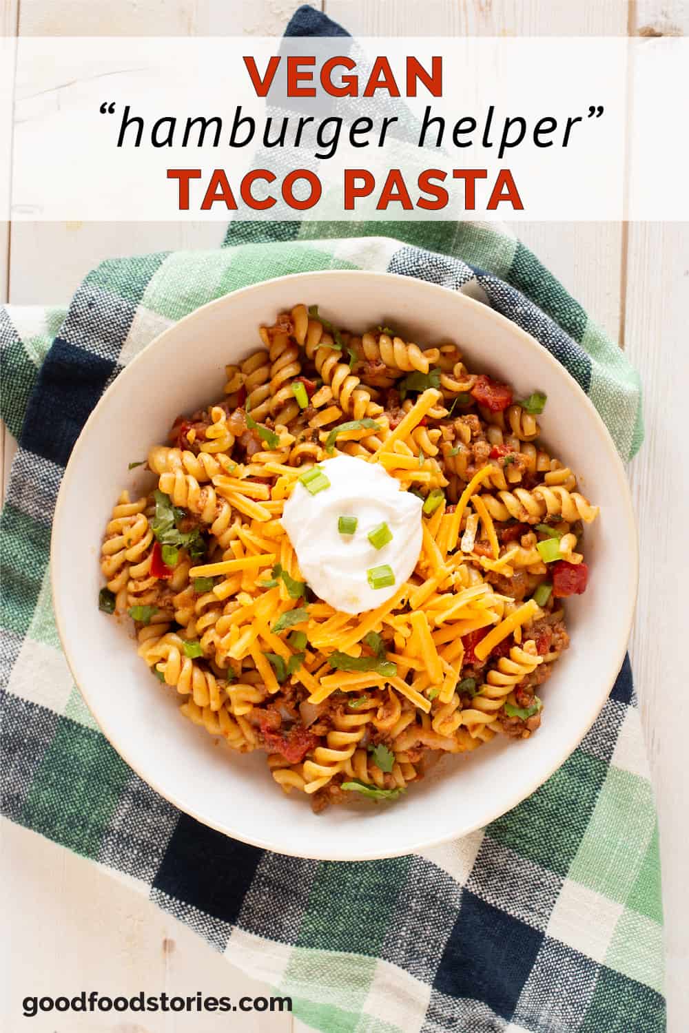 bowl of taco pasta topped with cheese and sour cream
