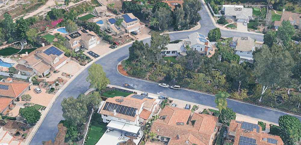Aerial view of a quiet Scripps Ranch residential street with large homes, mature trees, curved roads, and rooftop solar panels in San Diego