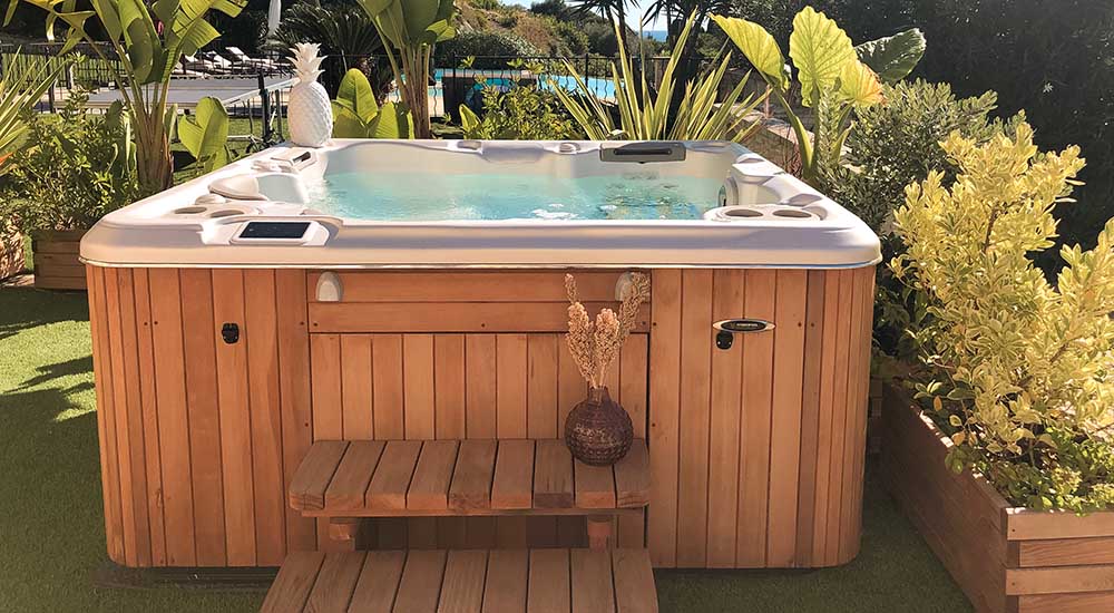 L'installation électrique d'un spa - Un spa est installé en extérieur, il est entouré de verdure.