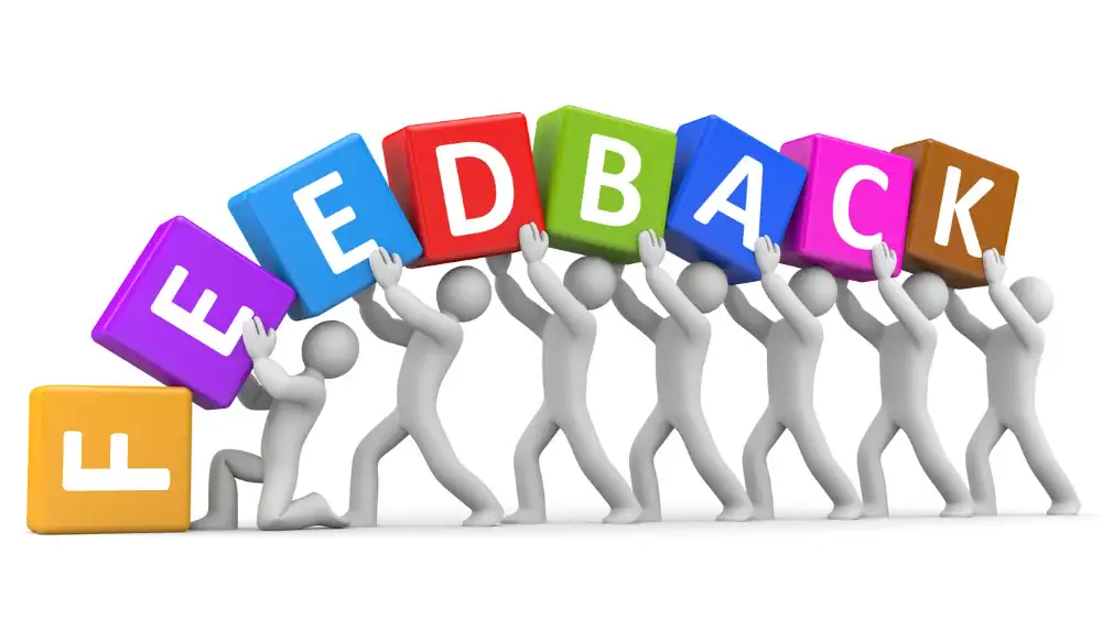 A student holding a sign that says feedback