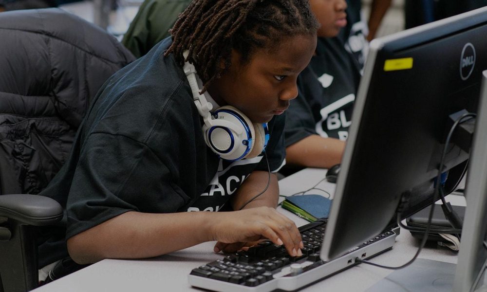Black boy looking at computer screen at computer course.