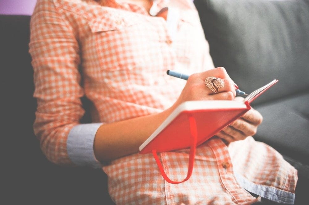 Woman writing in a journal.