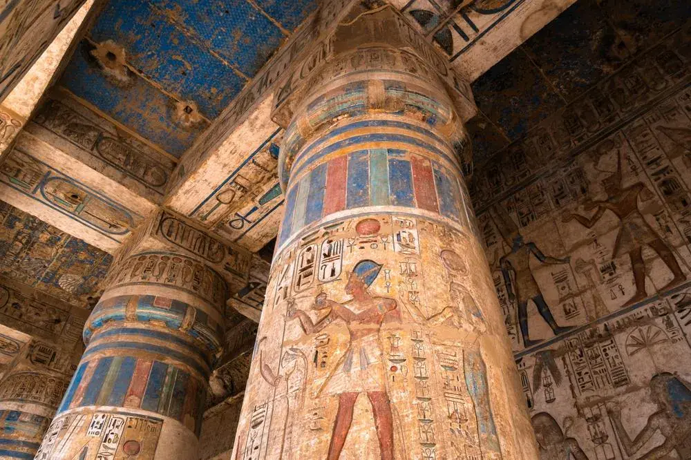 Decorated hypostyle hall columns inside Medinet Habu Temple