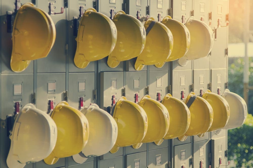 Safety helmets lined up in two rows on lockers.