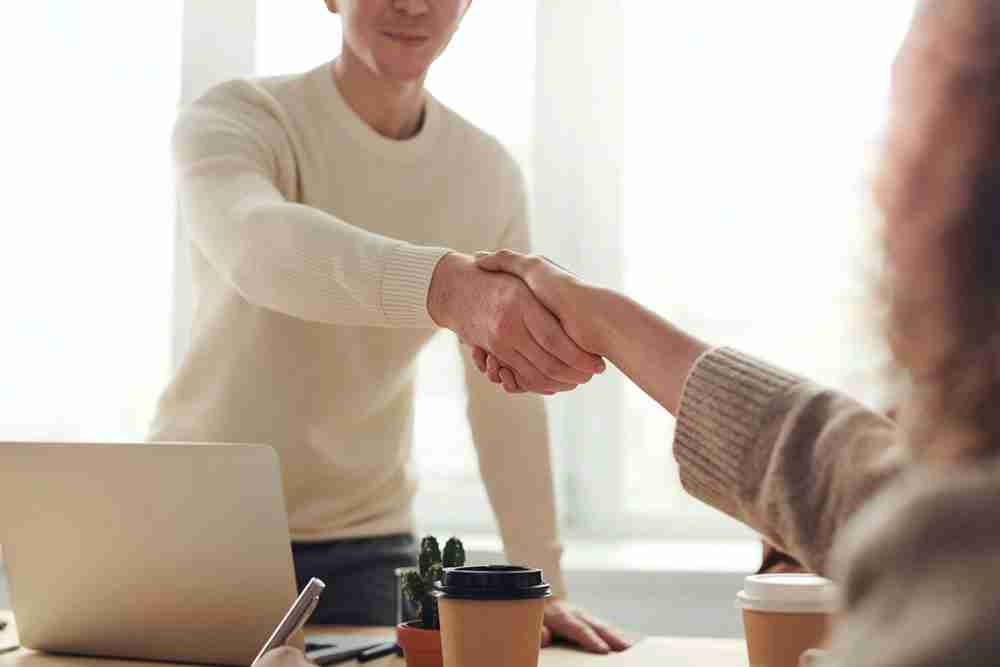 Two people shaking hands representing a job interview. Start somatic therapy in Michigan today.