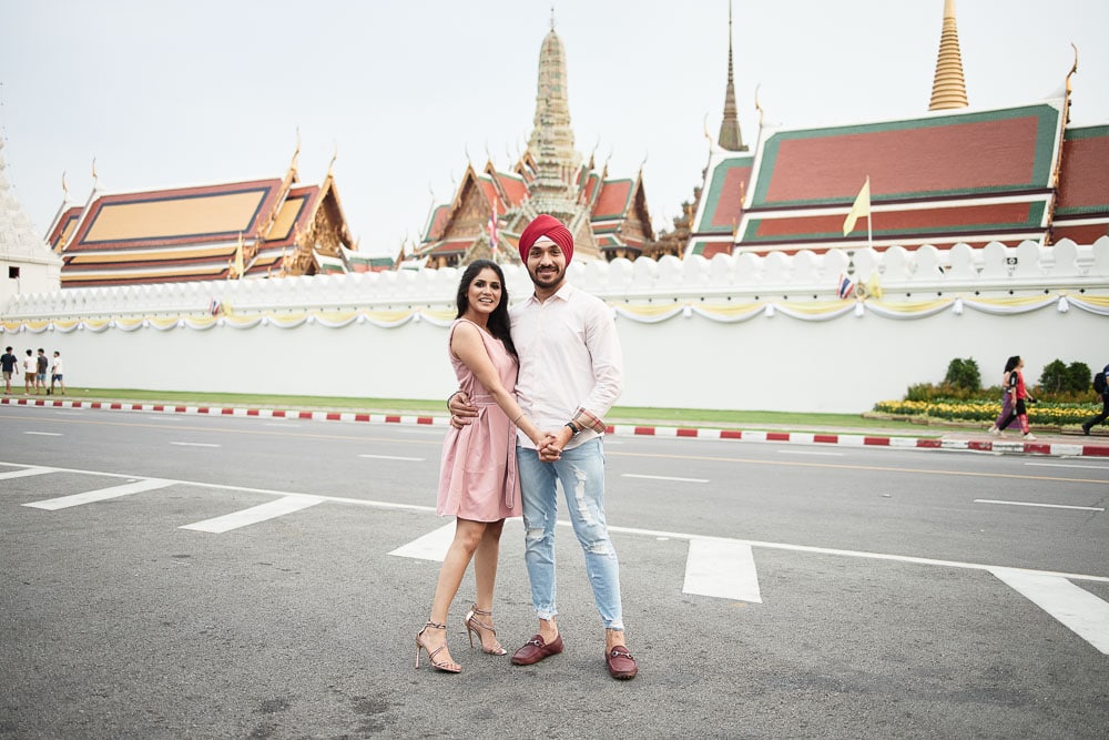 Couple posing in front of Bangkok temple architecture
