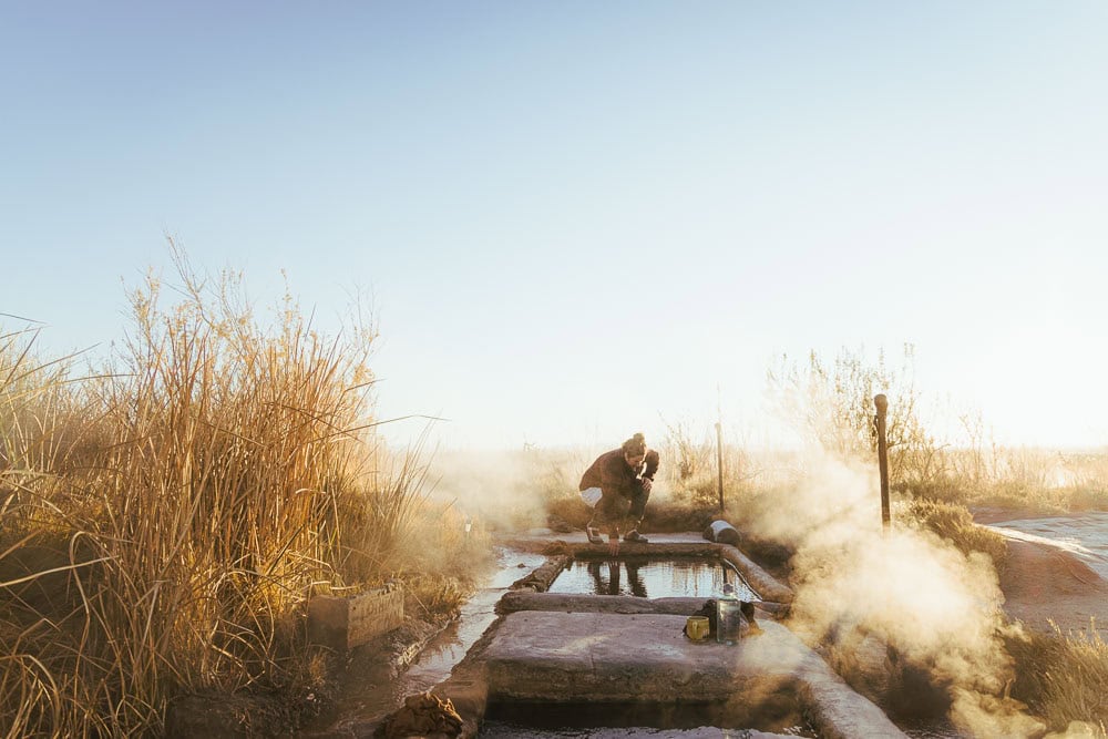 woman feeling hot spring water in the morning light, arboursabroad, Utah hot springs
