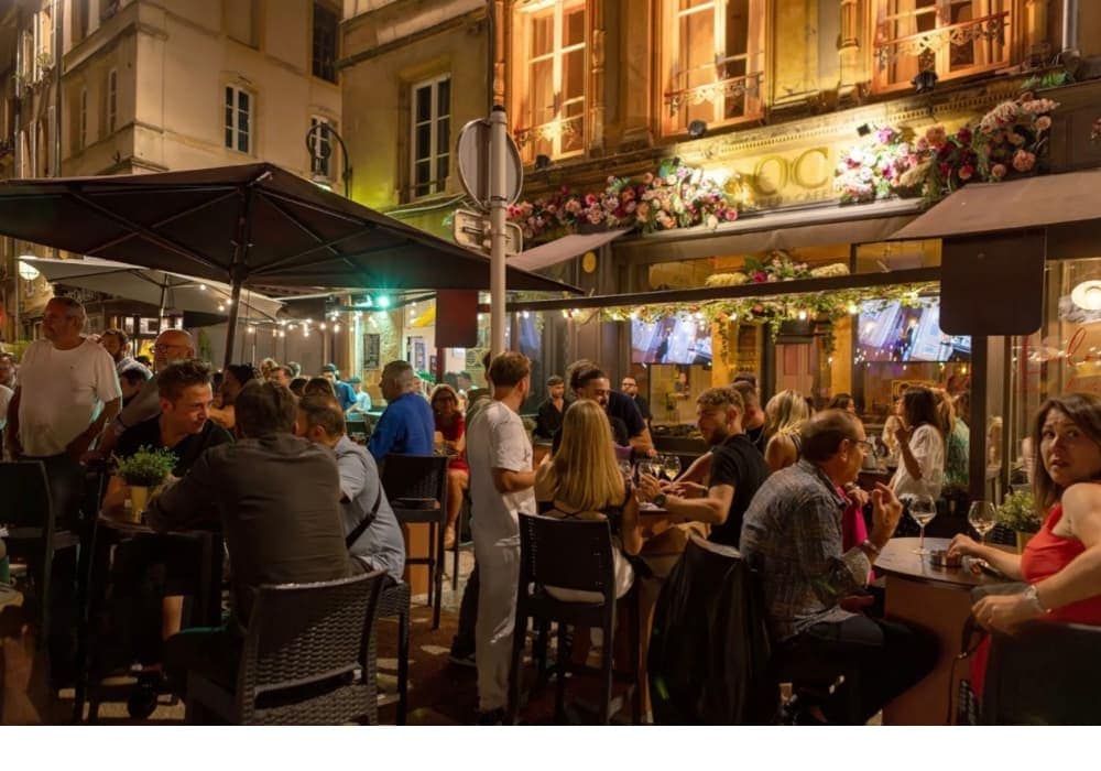 rue animée de Metz la nuit, nombreuses terrasses 