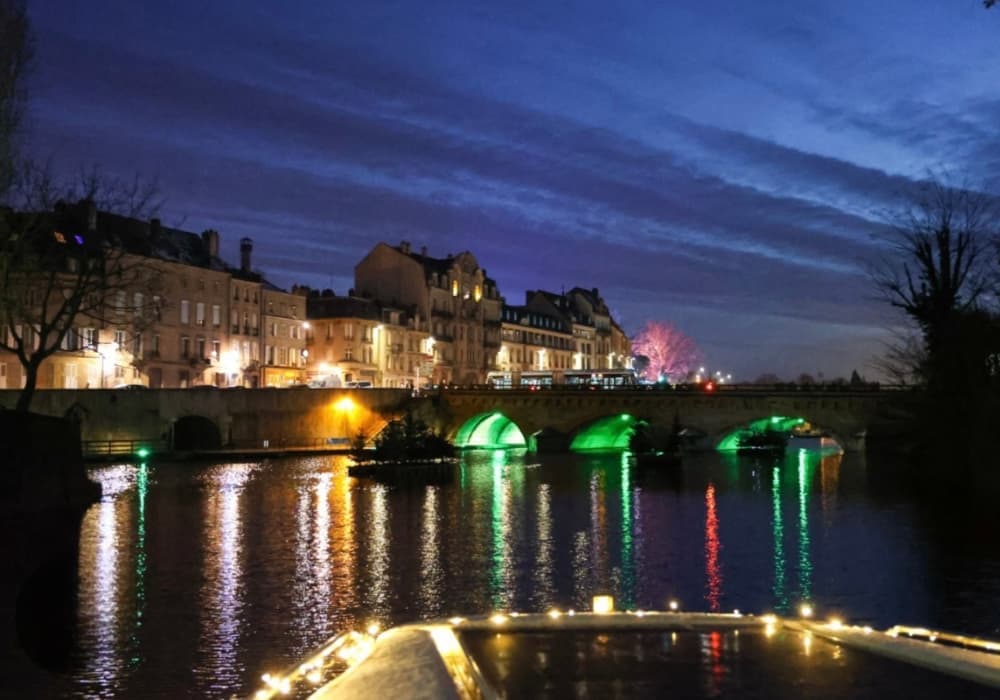 Vue du pont de Metz avec cathédrale et reflets sur l’eau de nuit