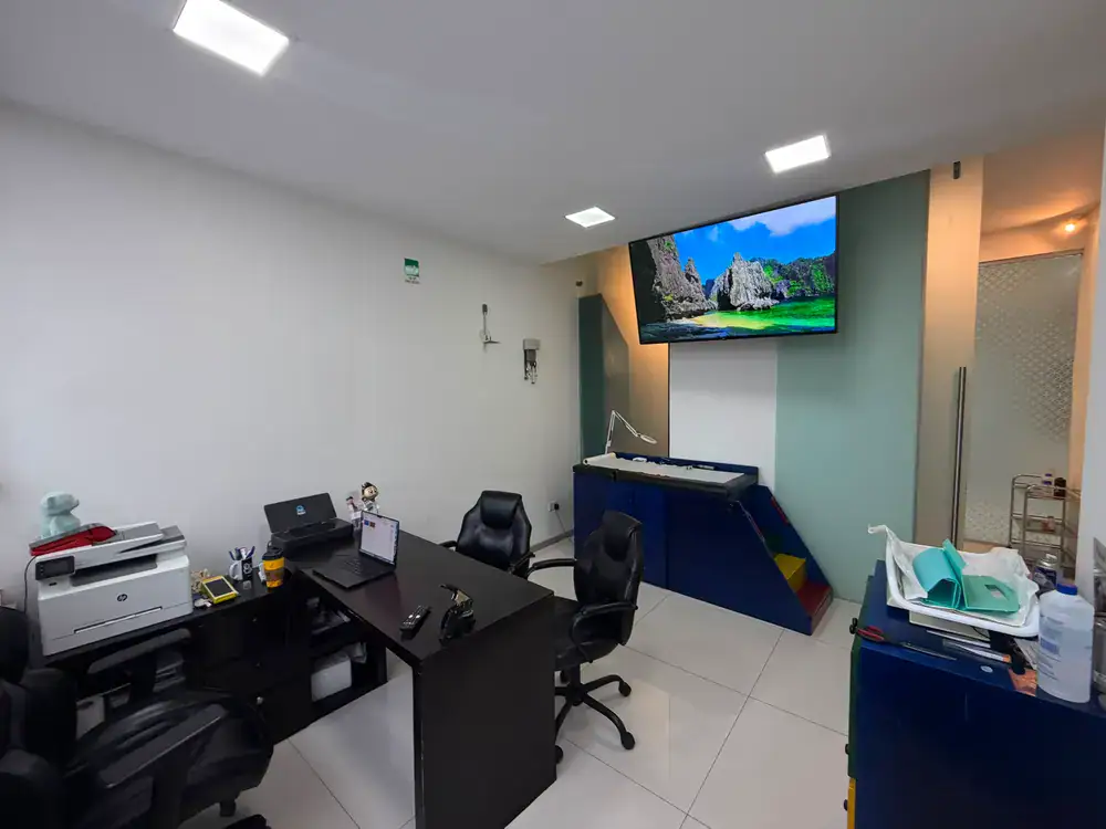 Cuarto de exploración pediátrica con camilla y pantalla de entretenimiento para niños