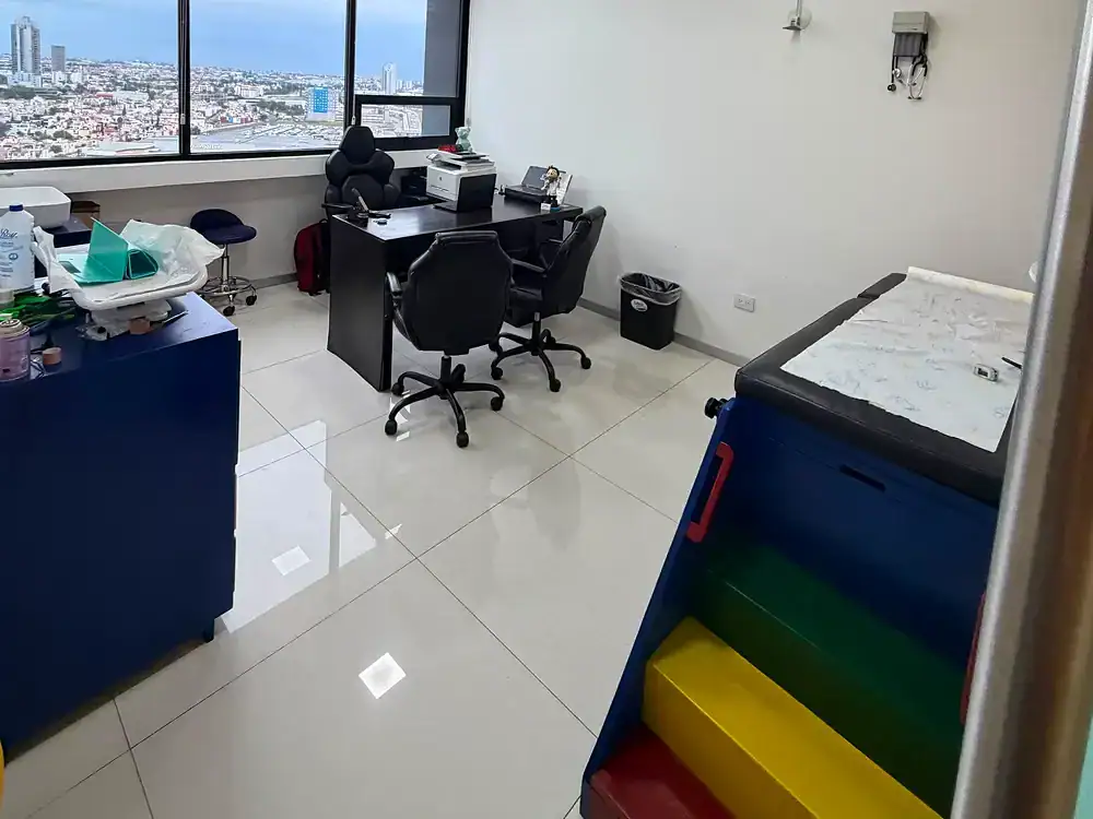 Consultorio pediátrico equipado con televisión y camilla de exploración