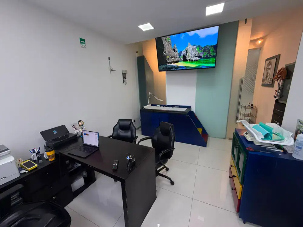 Cuarto de exploración pediátrica con mobiliario completo y área infantil