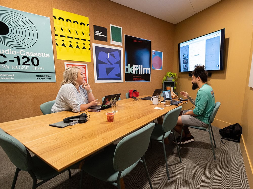 Duo of office workers presenting work over the TV