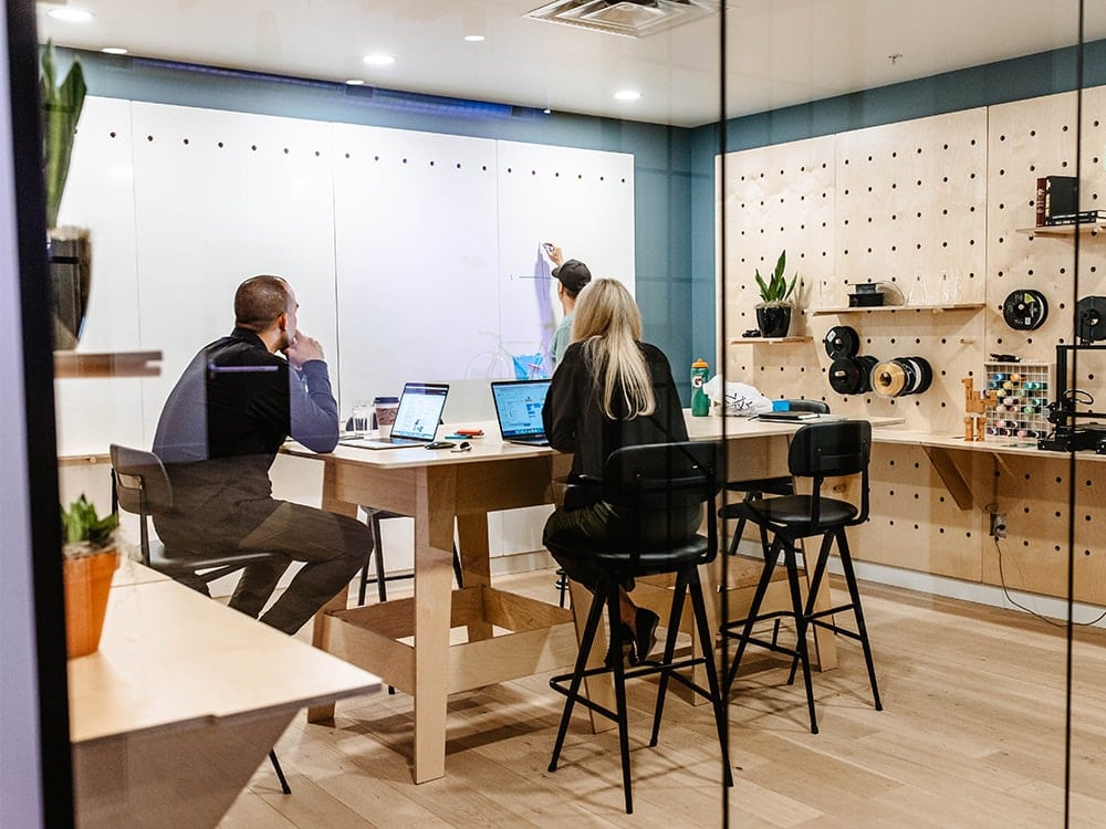 Group of office workers meeting while using the white board