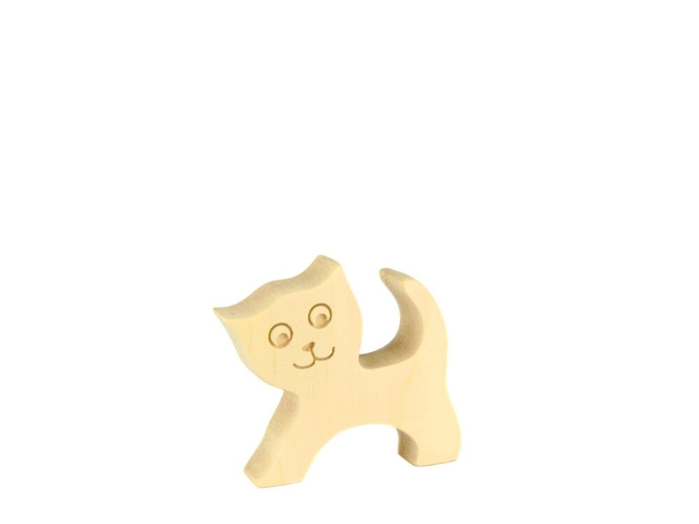 Dřevěná figurka kočičky se zvednutým ocasem a gravírovaným obličejem na bílém pozadí.