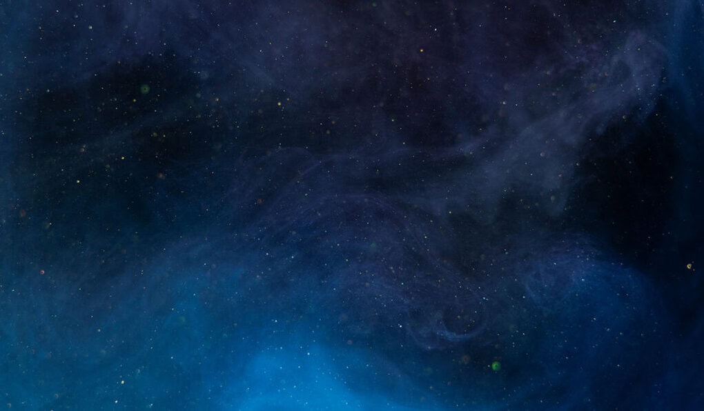 Deep blue, cosmic nebula background featuring a swirling mix of dark clouds, scattered stars, and subtle hints of starlight