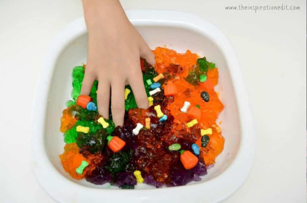 Edible Halloween themed sensory bin in orange, green and red