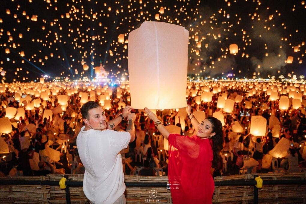 A couple release a paper lantern among thousands of floating lanterns during a surprise proposal at the Yi Peng festival in Chiang Mai