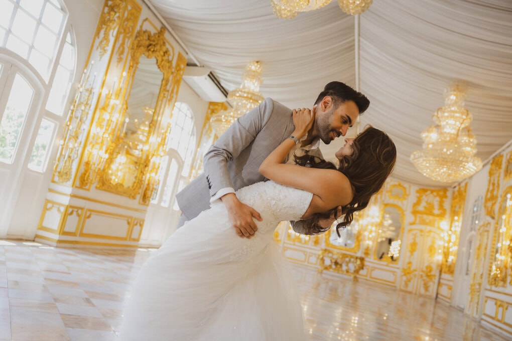 Jasras in a grey suit dips Simran in a white lace gown in the candlelit golden hall of Benedict Studio, Bangkok