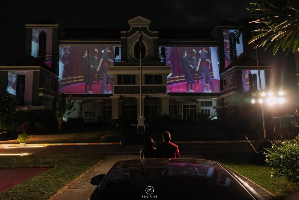 Couple photos projected onto a building at night for a projector proposal at TSI International School