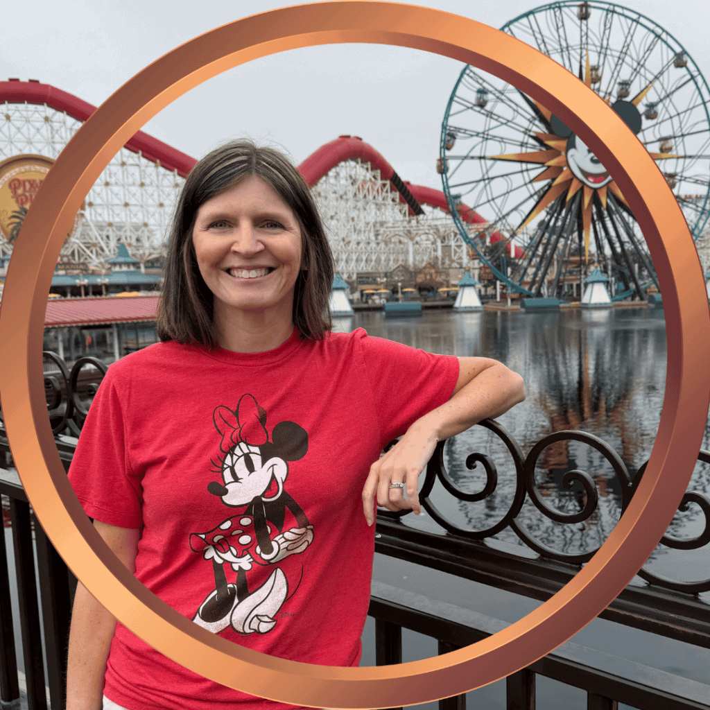 Woman smiling with Minnie Mouse shirt at Disneyland amusement park.
