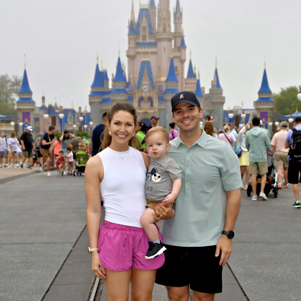 Family enjoying a Disney theme park vacation in front of Sleeping Beauty Castle.