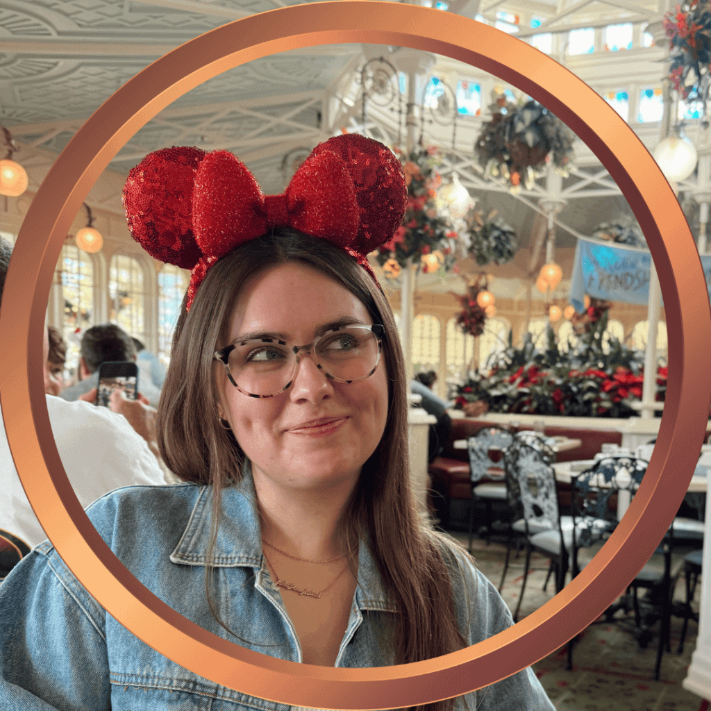 Girl with glasses and Minnie Mouse ears enjoying a Disney vacation celebration.