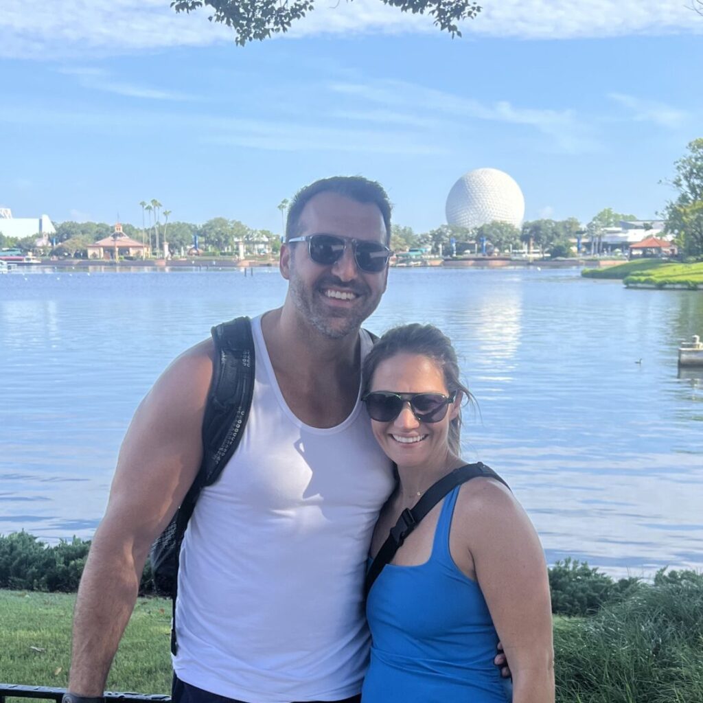 Vacation couple at Epcot, Disney World, Orlando with Spaceship Earth in the background.