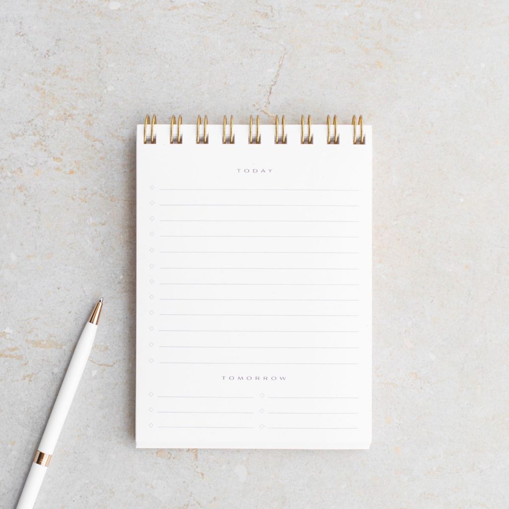 a spiral notebook and a pen