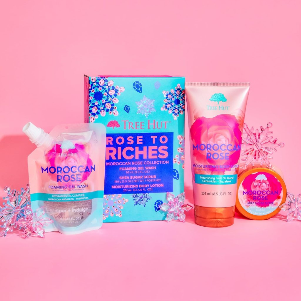 Tree Hut Holiday Rose to Riches Gift Set featuring Moroccan Rose Foaming Gel Wash, Shea Sugar Scrub, and Moisturizing Body Lotion on a pink background.