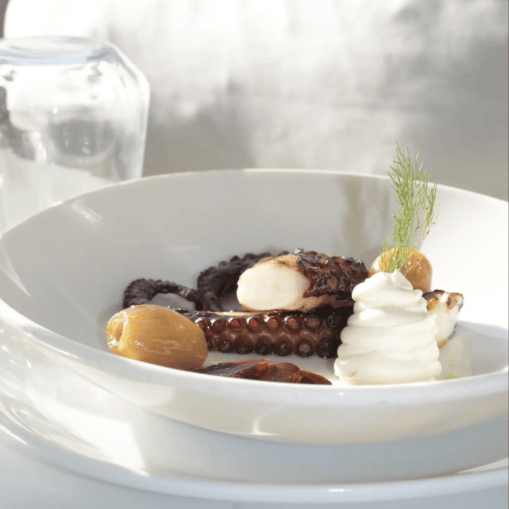 Grilled octopus with mashed potato, olives and herbs — signature seafood starter at Nautilus Mykonos restaurant.