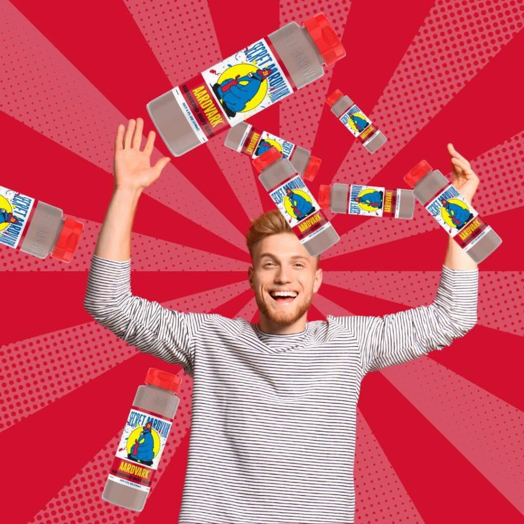 A happy man joyously tosses bottles of Secret Aardvark Hot Sauce into the air.