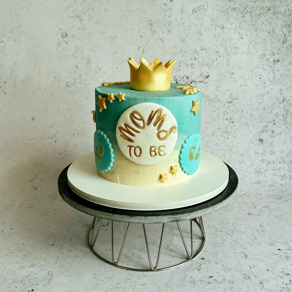 Tort na baby shower w wersji dla mamy chłopca w kolorze biało niebieskim ze złotymi gwiazdkami i korona